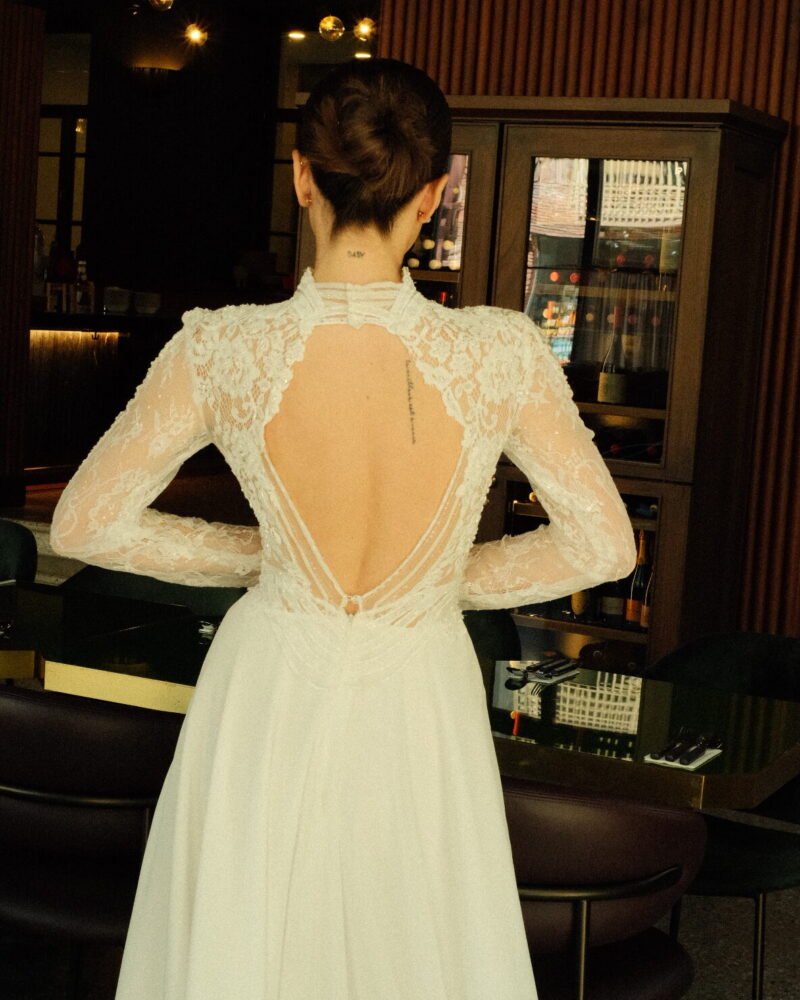 Vintage-inspired lace wedding dress with a high neckline, long sleeves, and sheer back, Chic Delight Photo 03